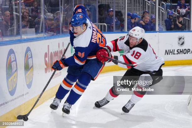 Alexander Romanov of the New York Islanders controls puck against Ondrej Palat of the New Jersey Devils at UBS Arena on March 24, 2024 in Elmont, New...
