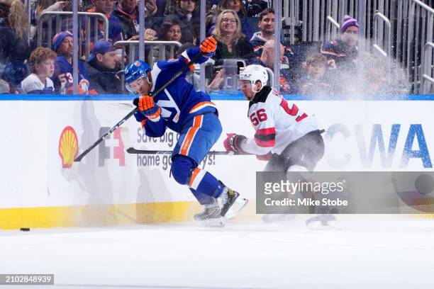 Mathew Barzal of the New York Islanders races to puck against Erik Haula of the New Jersey Devils at UBS Arena on March 24, 2024 in Elmont, New York.
