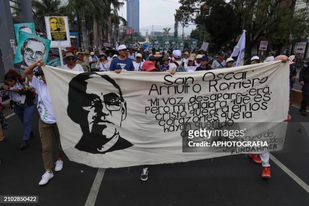 People carry banner and posters of Romero during the commemoration activities of the 44th anniversary of the assassination of archbishop Oscar...
