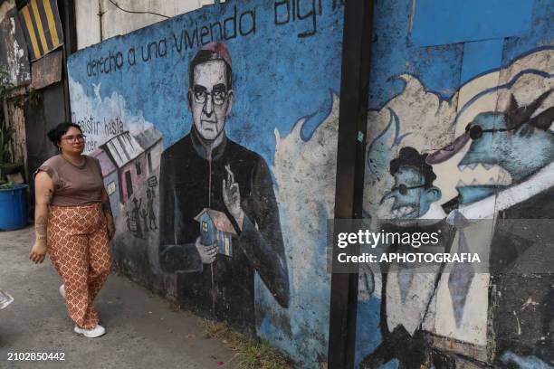 Woman walks in front of a Romero mural during the commemoration activities of the 44th anniversary of the assassination of archbishop Oscar Arnulfo...