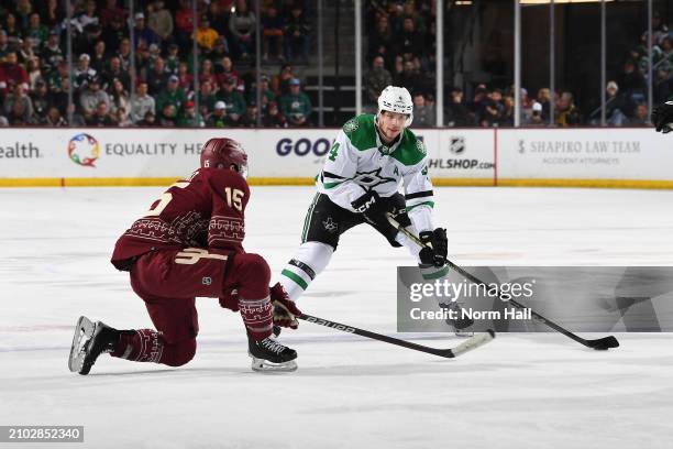 Miro Heiskanen of the Dallas Stars skates with the puck while being defended by Alex Kerfoot of the Arizona Coyotes during the second period of the...
