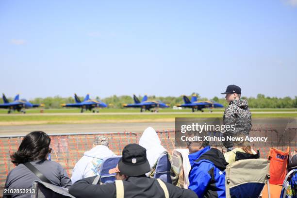 People watch the aerobatics show during the New Orleans Airshow at Naval Air Station Joint Reserve Base in Belle Chasse, Louisiana, the United...