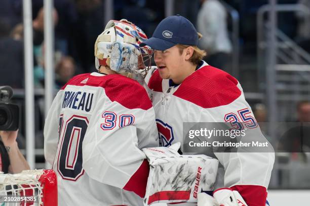 Cayden Primeau of the Montreal Canadiens and Sam Montembeault hug after a game against the Seattle Kraken at Climate Pledge Arena on March 24, 2024...