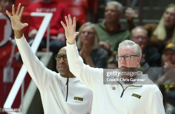 Head coach Fran McCaffery of the Iowa Hawkeyes and assistant coach Sherman Dillard call in a play during the second half of the second round of the...