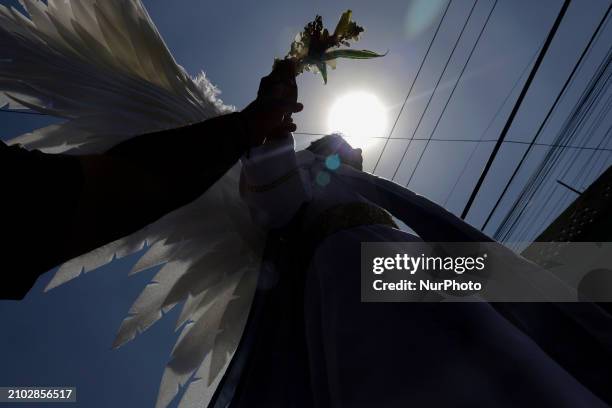 Young man dressed as an angel is accompanying another young man dressed as Jesus Christ on the streets of Culhuacan in the southern end of Mexico...