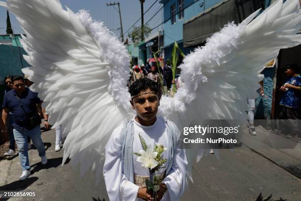 Young man dressed as an angel is accompanying another young man dressed as Jesus Christ on the streets of Culhuacan in the southern end of Mexico...