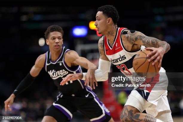 Kyle Kuzma of the Washington Wizards dribbles past Kessler Edwards of the Sacramento Kings during the first half at Capital One Arena on March 21,...