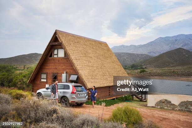 smiling friends arriving at a cabin in a nature reserve during a vacation - car rental stock pictures, royalty-free photos & images