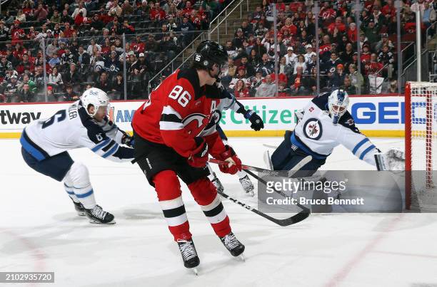 Laurent Brossoit of the Winnipeg Jets makes the second period save on Jack Hughes of the New Jersey Devils at Prudential Center on March 21, 2024 in...
