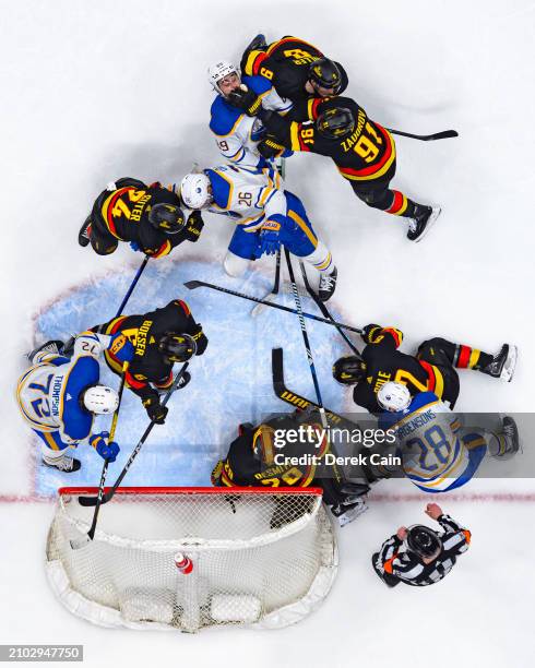 Ian Cole Brock Boeser Pius Suter Nikita Zadorov J.T. Miller and Casey DeSmith of the Vancouver Canucks defend against Rasmus Dahlin Tage Thompson...