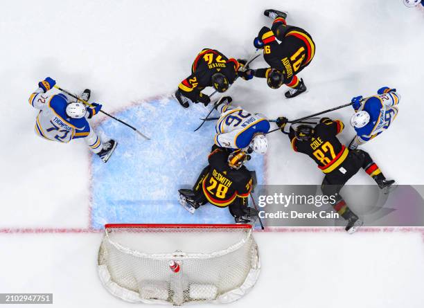 Ian Cole and Casey DeSmith of the Vancouver Canucks defend against Rasmus Dahlin of the Buffalo Sabres during the first period of their NHL game at...