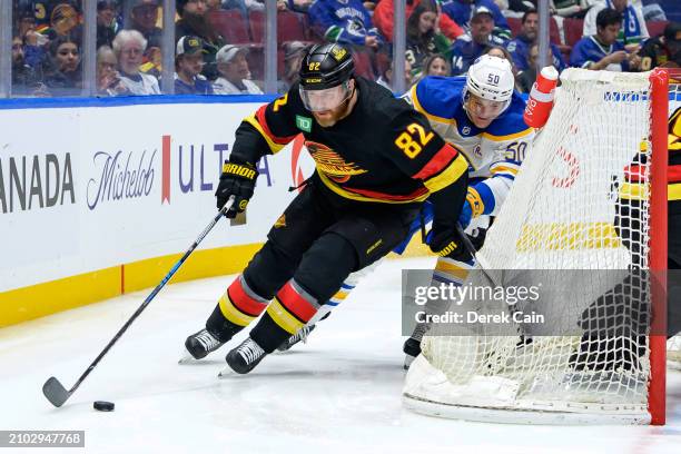 Ian Cole of the Vancouver Canucks is pursued by Eric Robinson of the Buffalo Sabres during the second period of their NHL game at Rogers Arena on...