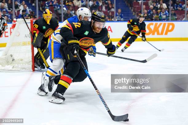 Casey DeSmith looks on as Ian Cole of the Vancouver Canucks is pursued by Eric Robinson of the Buffalo Sabres during the second period of their NHL...