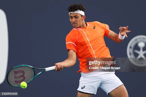 Emilio Nava of the United States returns a shot to Roberto Bautista Agut of Spain during his men's singles match during the Miami Open at Hard Rock...