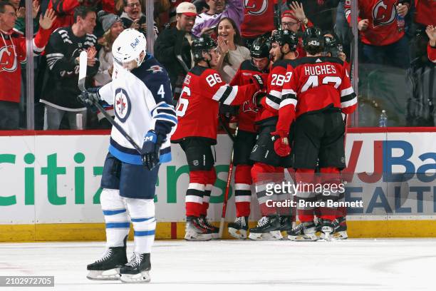 The New Jersey Devils celebrate a third period goal by Nico Hischier against the Winnipeg Jets at Prudential Center on March 21, 2024 in Newark, New...