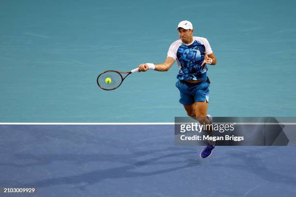 Dusan Lajovic of Serbia returns a shot to Gael Monfils of France during his men's singles match during the Miami Open at Hard Rock Stadium on March...