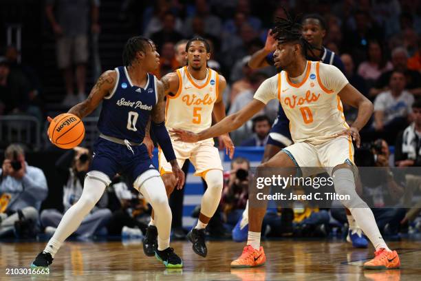 Latrell Reid of the Saint Peter's Peacocks dribbles against Jonas Aidoo of the Tennessee Volunteers during the first half in the first round of the...