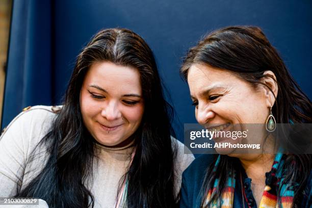 digital bonding: indigenous women share a tech-infused moment at the table - indigenous canadians stock pictures, royalty-free photos & images