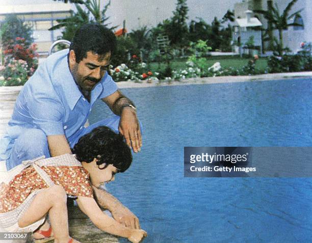 In this undated photo, Saddam Hussein plays with his daughter, Hala, at a swimming pool.
