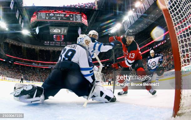 Nico Hischier of the New Jersey Devils scores at 5:59 of the third period against Laurent Brossoit of the Winnipeg Jets at Prudential Center on March...