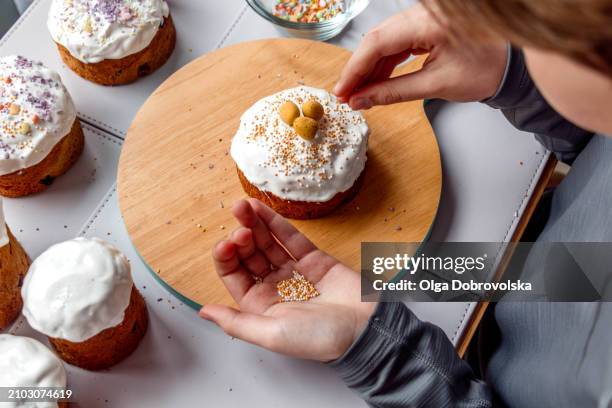 boy decorating an easter cake - osterkuchen stock-fotos und bilder