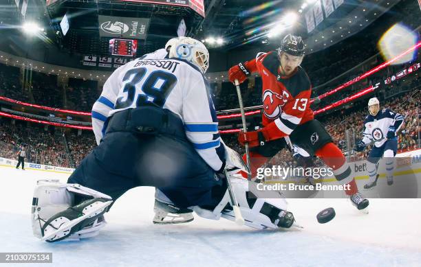 Nico Hischier of the New Jersey Devils scores at 5:59 of the third period against Laurent Brossoit of the Winnipeg Jets at Prudential Center on March...