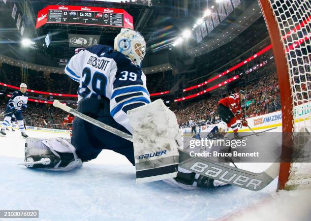 Laurent Brossoit of the Winnipeg Jets tends net against the New Jersey Devils at Prudential Center on March 21, 2024 in Newark, New Jersey. The...