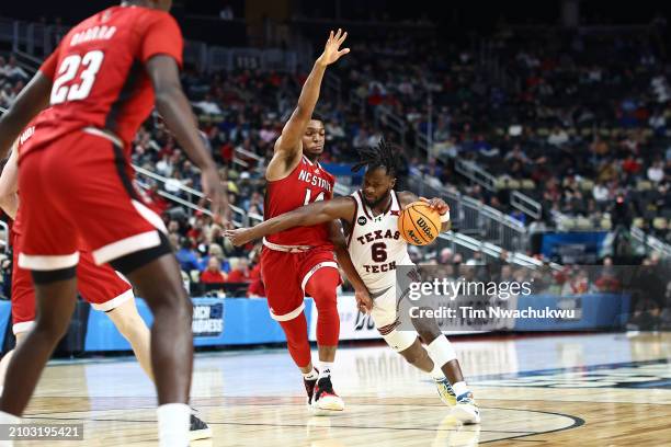 Joe Toussaint of the Texas Tech Red Raiders drives against Casey Morsell of the North Carolina State Wolfpack during the second half in the first...