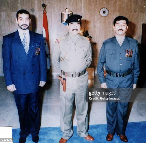 In this undated photo, Saddam Hussein poses with his sons Uday and Qusay . Officials say the United States is offering a $25 million reward for any...