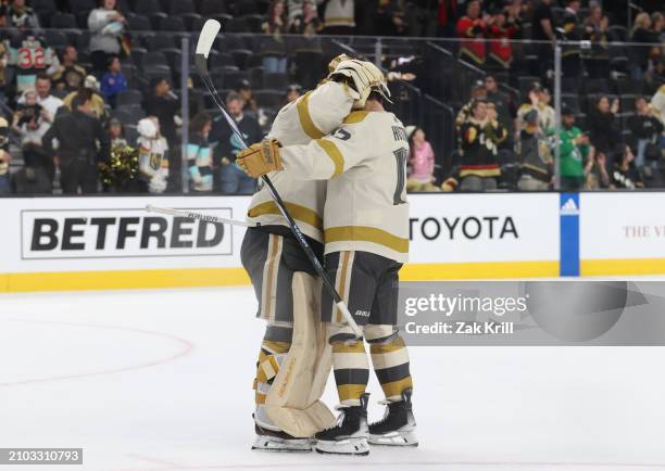 Logan Thompson of the Vegas Golden Knights celebrates with Ben Hutton after a 3-1 victory against the Seattle Kraken at T-Mobile Arena on March 21,...