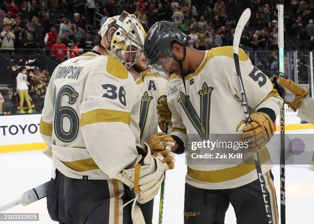 Logan Thompson of the Vegas Golden Knights celebrates with Keegan Kolesar after a 3-1 victory against the Seattle Kraken at T-Mobile Arena on March...