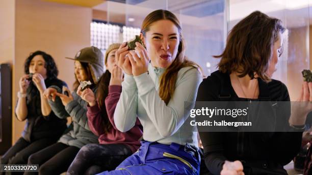 cheerful woman eating onigiri with friends in niseko hotel lobby - rice ball stock pictures, royalty-free photos & images