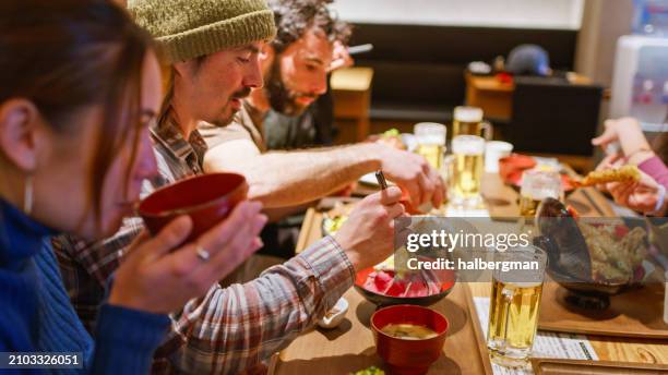 three friends having dinner with their friends after skiing - japan food stock pictures, royalty-free photos & images