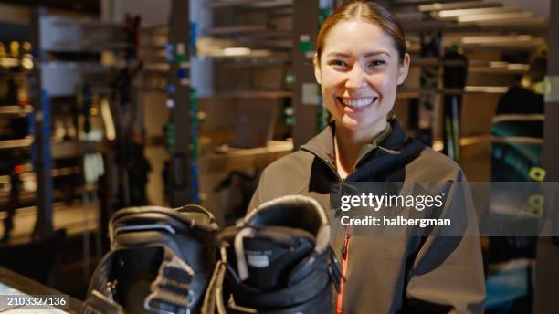 rental shop worker with pair of ski boots inside niseko hotel - skier portrait stock pictures, royalty-free photos & images