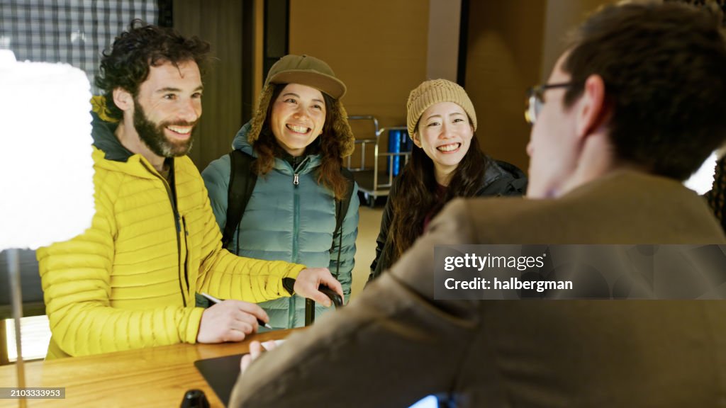 Three Best Friends Looking at Receptionist inside Niseko Hotel