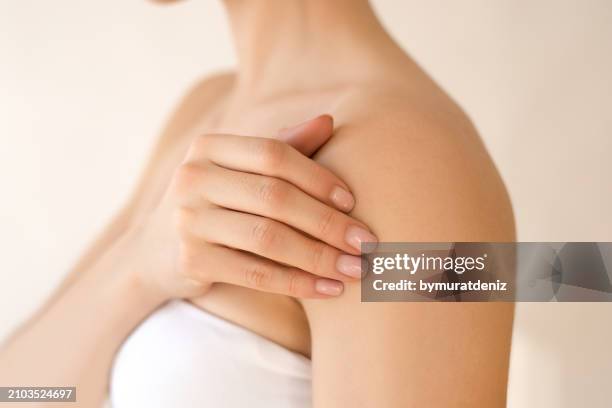 woman toughing her soft skin - beautiful woman shoulder stock pictures, royalty-free photos & images