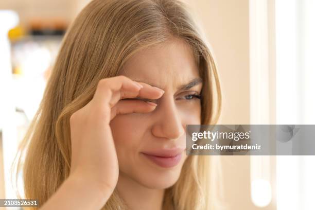 woman rubbing eyes - frotar fotografías e imágenes de stock