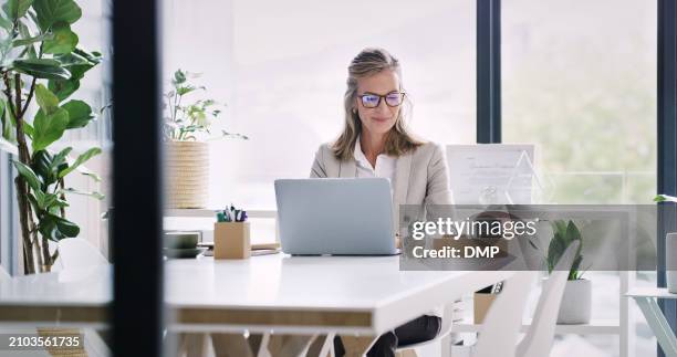 mature woman, entrepreneur and work with laptop in office for online, information and research for company ideas. boss, female person and ceo with vision on internet for e commerce and business - entrepreneur stockfoto's en -beelden