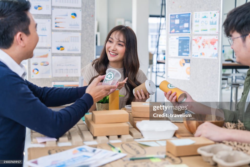 Creative product design businesswoman holding various packages and recyclepaper material that she is arranging on her desk she is thinking esg project for enery green and net zero save the earth concept