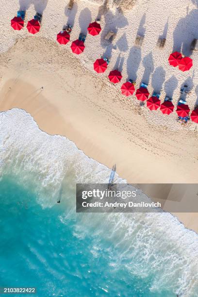 vue aérienne de parasols rouges sur une plage de sable et d’océan bleu, bali. - parasol de plage photos et images de collection