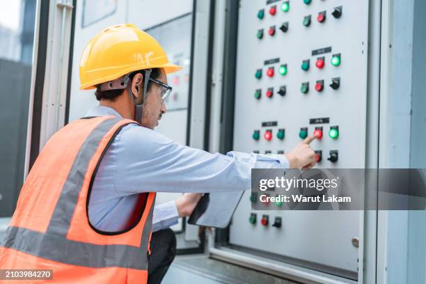 technician adjusting controls on electrical cabinet - control cabinet stock pictures, royalty-free photos & images