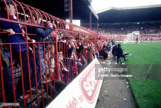 Young fans watch the game from behind the Perimeter safety fence at the Stretford End of the ground during a First Division match against Leicester...