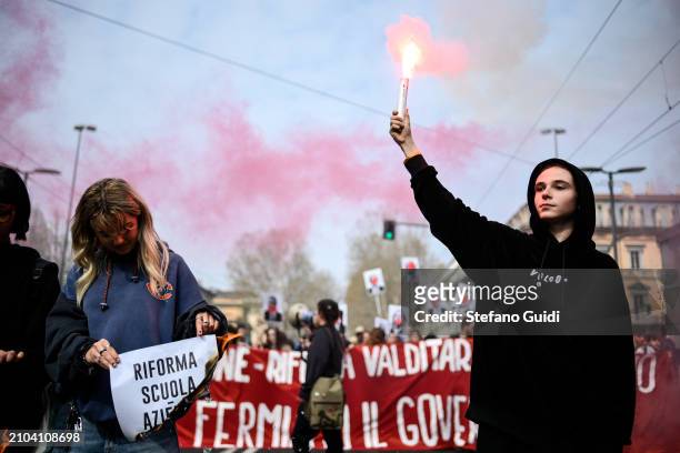 Student hold a red smoke bomb during a protest against the Italian government on March 22, 2024 in Turin, Italy. Students associations protest...