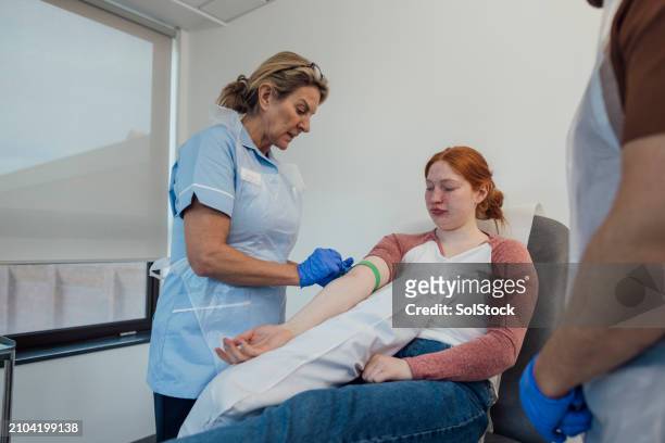 nurse and doctor treating patient - medical examination room stock pictures, royalty-free photos & images
