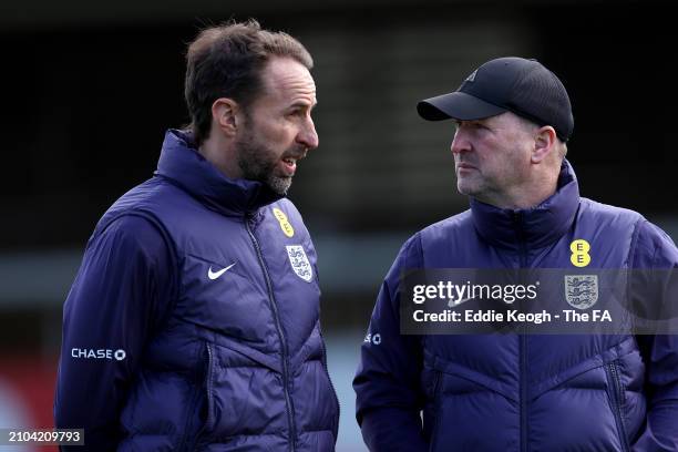 Gareth Southgate, Manager of England men's senior team, and Steve Holland talk during a training session at St Georges Park on March 22, 2024 in...