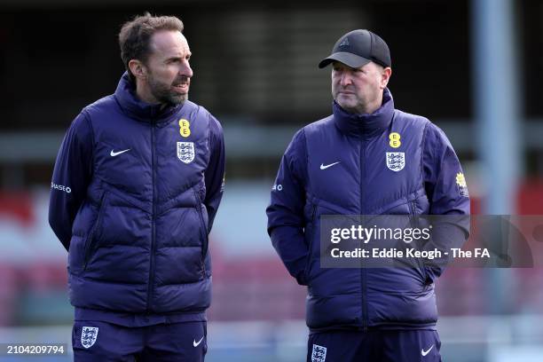 Gareth Southgate, Manager of England men's senior team, and Steve Holland talk during a training session at St Georges Park on March 22, 2024 in...