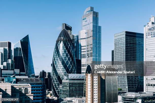 modern shiny skyscrapers in city of london on a sunny day with clear blue sky, aerial view, london, uk - city di londra foto e immagini stock
