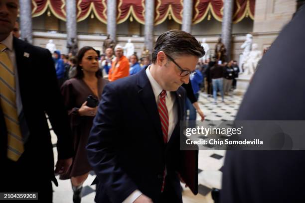 With his head bowed, Speaker of the House Mike Johnson speeds from his office past journalists and to the House Chamber ahead of a vote on a federal...