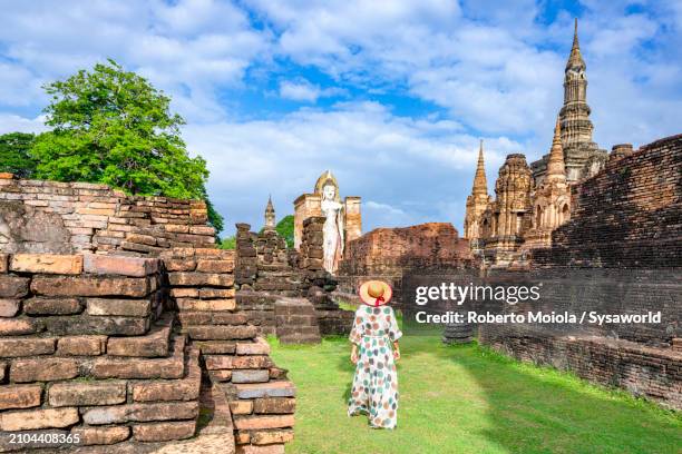 cheerful woman admiring the old ruins of a buddhist temple - wat phra mahathat stock pictures, royalty-free photos & images