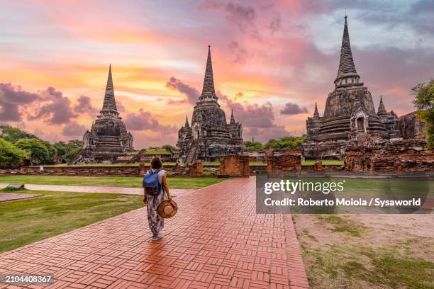 woman walking to wat phra si sanphet temple at dawn, thailand - thailändische kultur stock-fotos und bilder